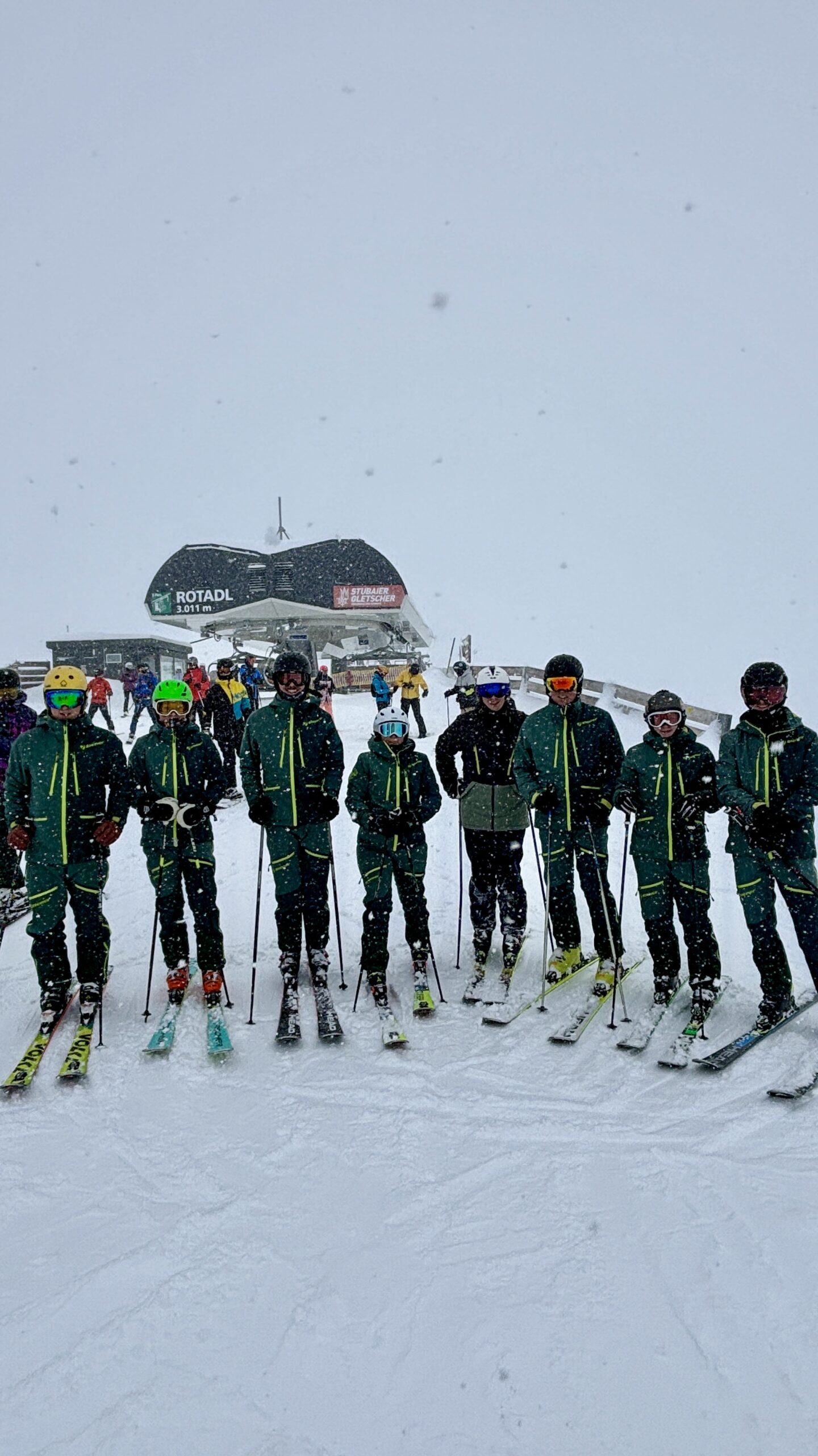 Gruppenfoto der Übungsleiter bei Schneefall am Berg, Skilift im Hintergrund