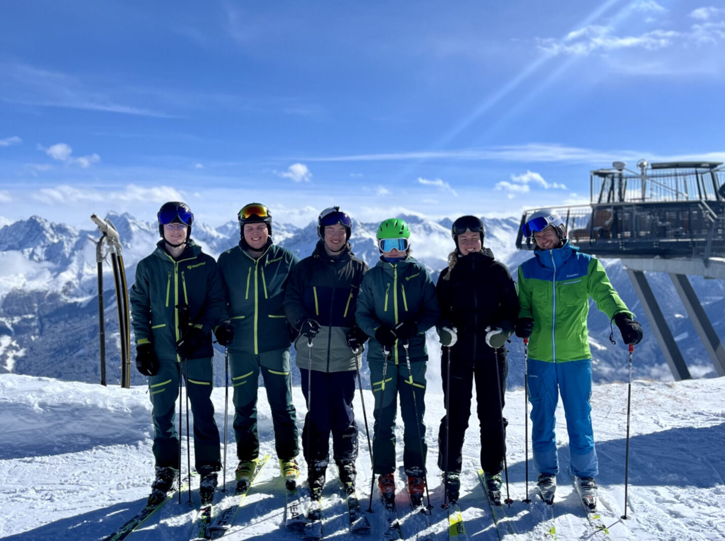 Foto von sechs Übungsleitern auf einem Berg, Skilift im Hintergrund