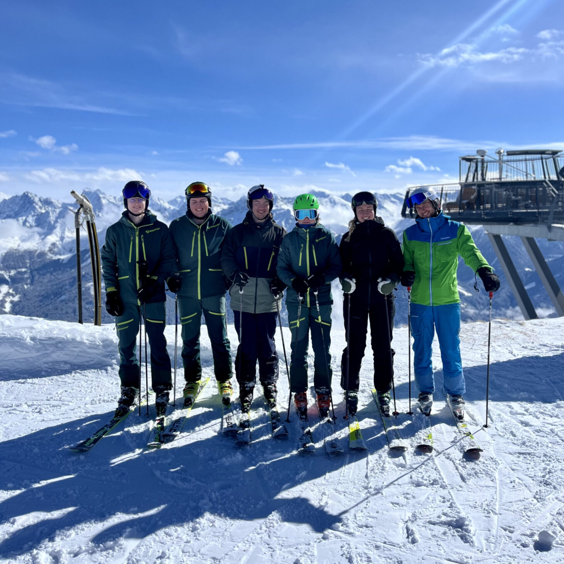 Foto von sechs Übungsleitern auf einem Berg, Skilift im Hintergrund