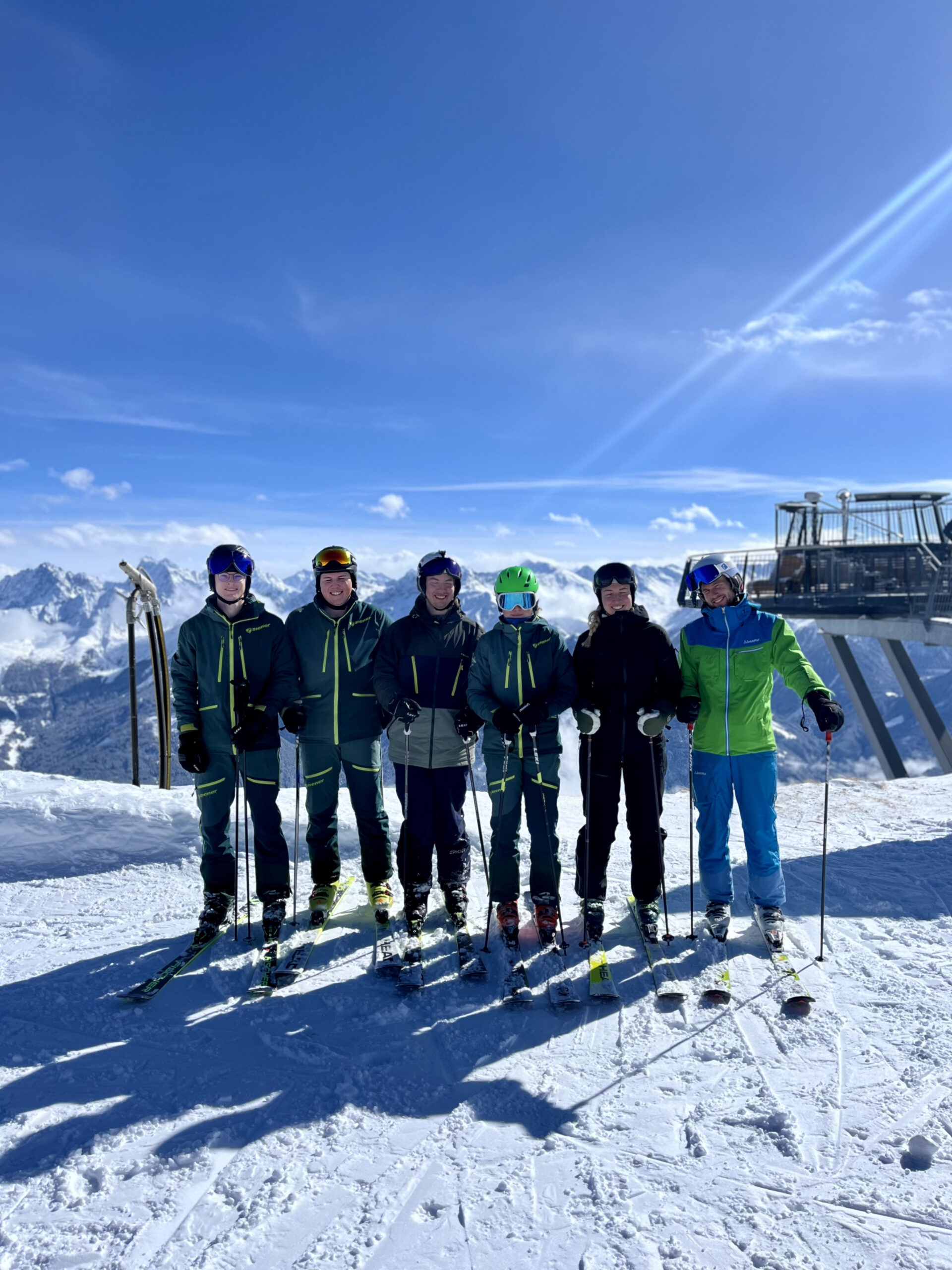 Foto von sechs Übungsleitern auf einem Berg, Skilift im Hintergrund